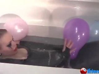 Latex dressed girlfriend with balloons in a bathtub