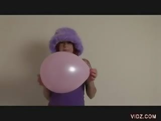 Charming street girl rubs puss against balloon